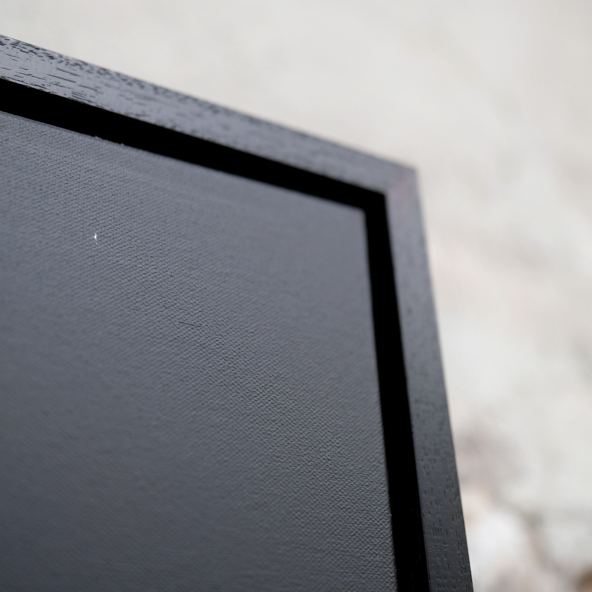 Angled close-up of the upper-right corner of Afterlight, showing the grey painted canvas and black frame.