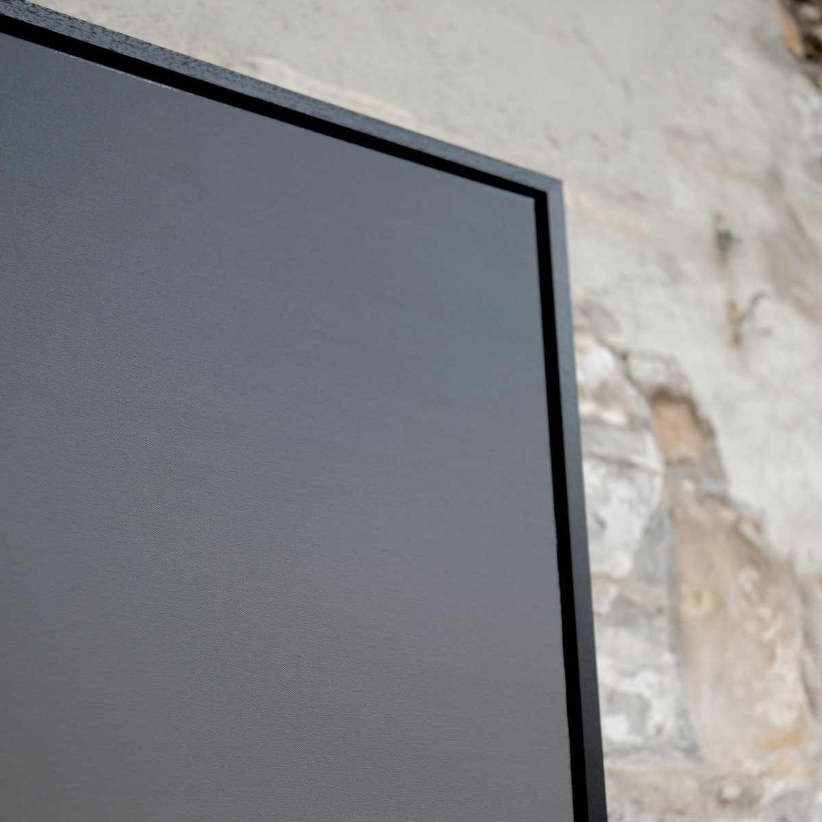 Angled close-up of the upper-right corner of Rosewake, showing grey painted sky, subtle surface texture and the black frame.