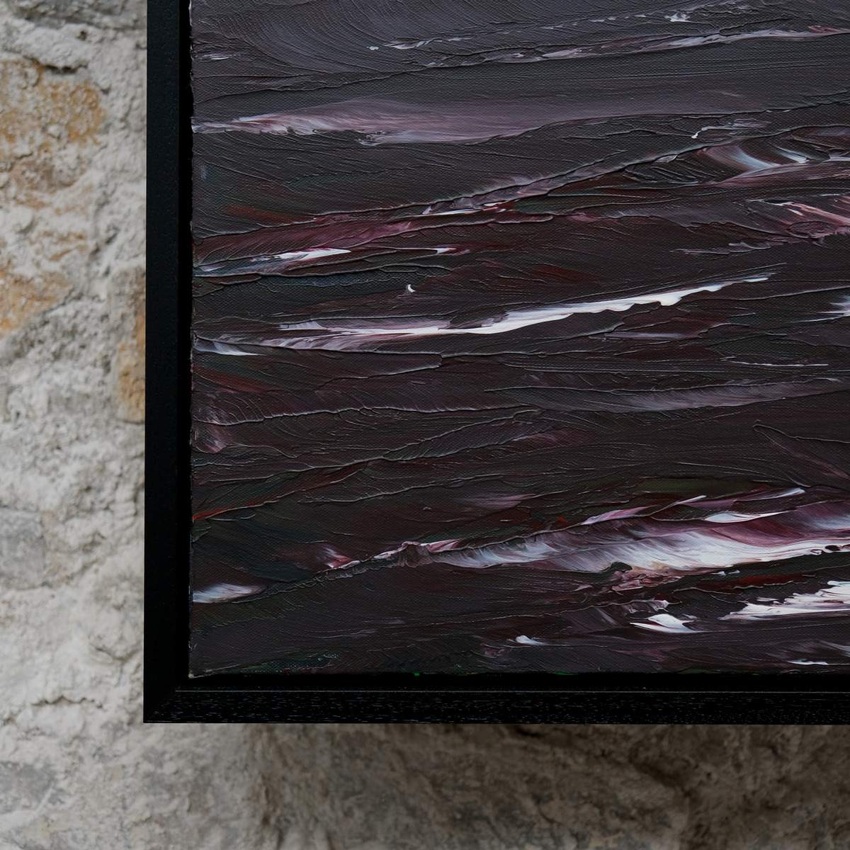 Close-up of the lower-left corner of The Sea Unquiet, showing raised charcoal, wine-red and violet paint with white wave marks beside the black frame.