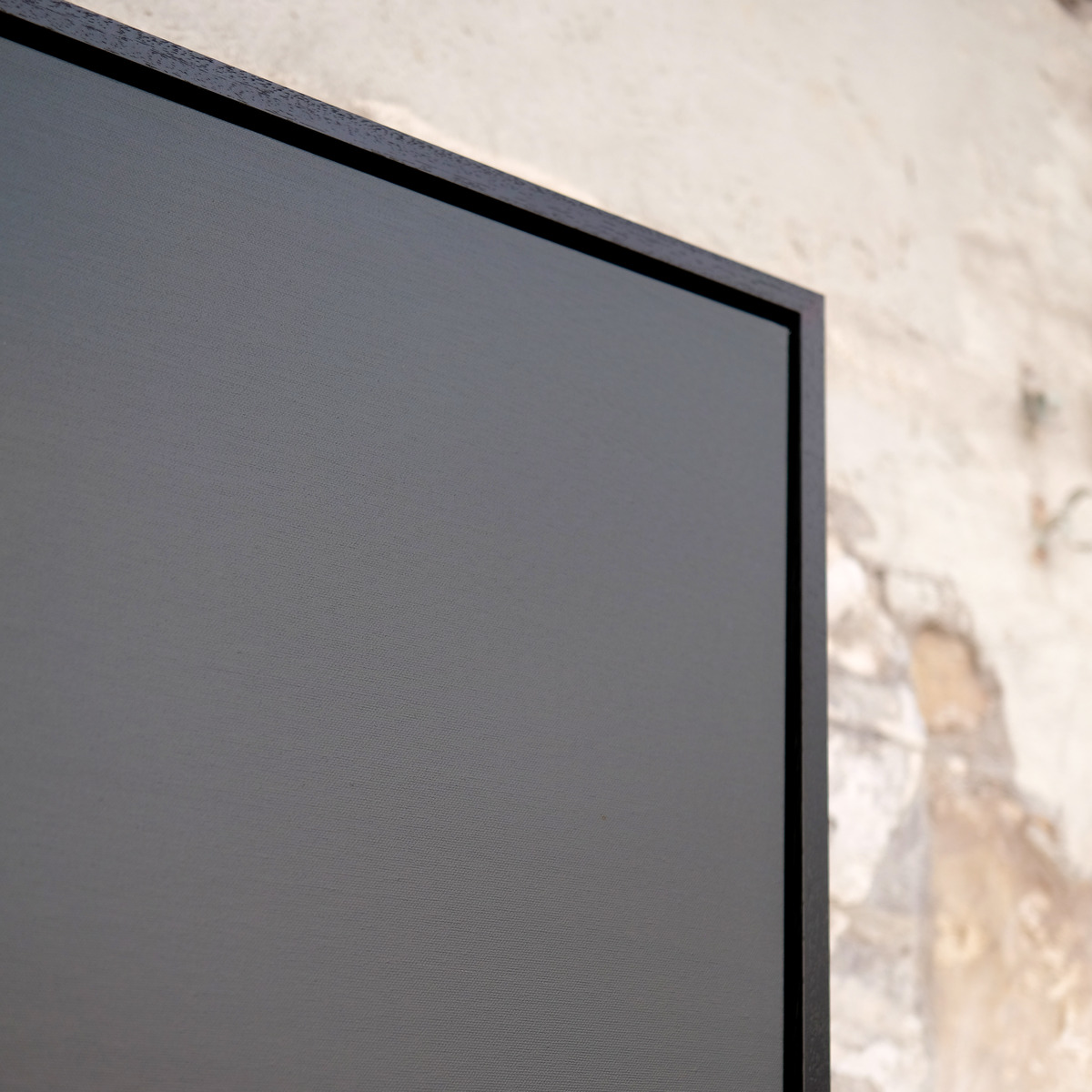 Angled close-up of the upper-right corner of The Quiet Line, showing the muted grey-violet sky, canvas texture and black frame.