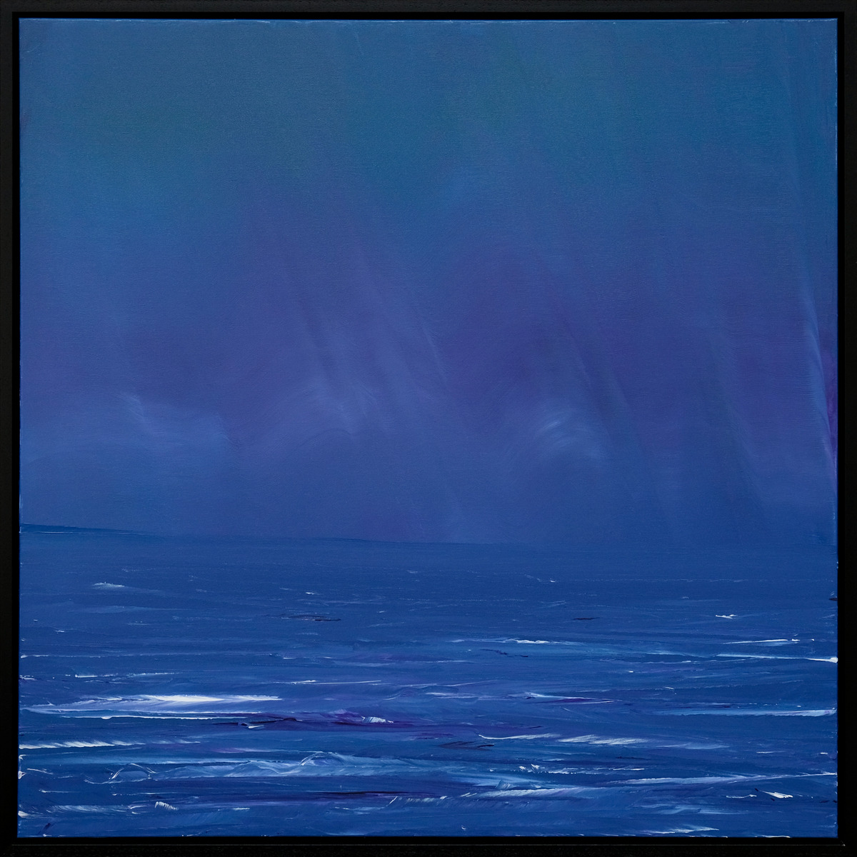 A seascape in deep blue, with pale sweeping marks across a broad sky, a low horizon and short white wave crests in a black frame.