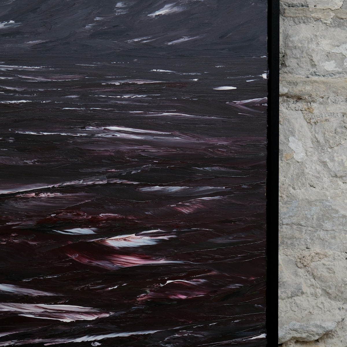 Detail of The Sea Unquiet showing a dark grey sky above wine-red and violet water, broken white strokes and the right edge of the black frame.